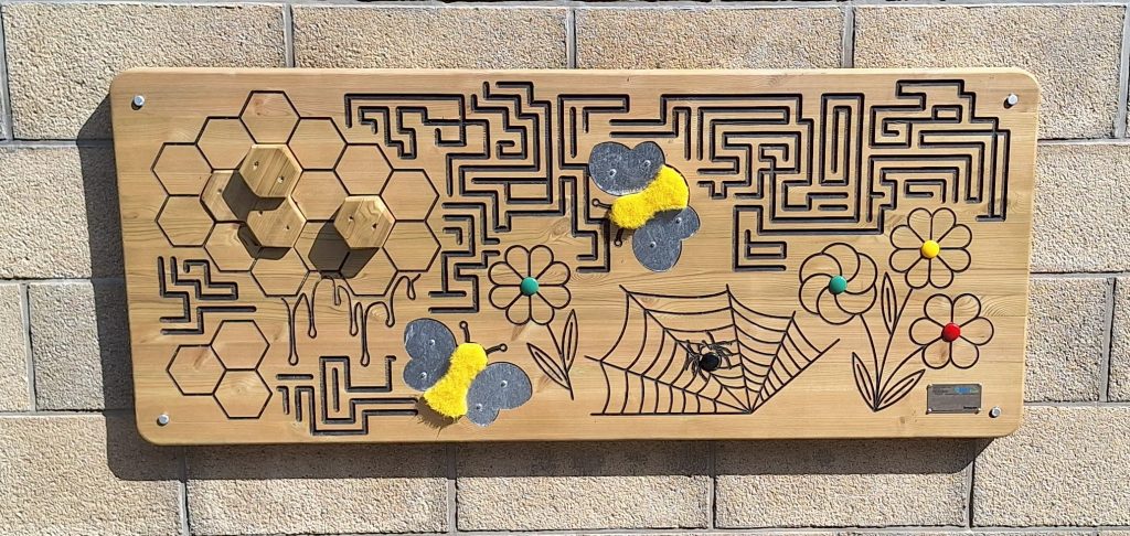 A wall mounted wooden finger maze